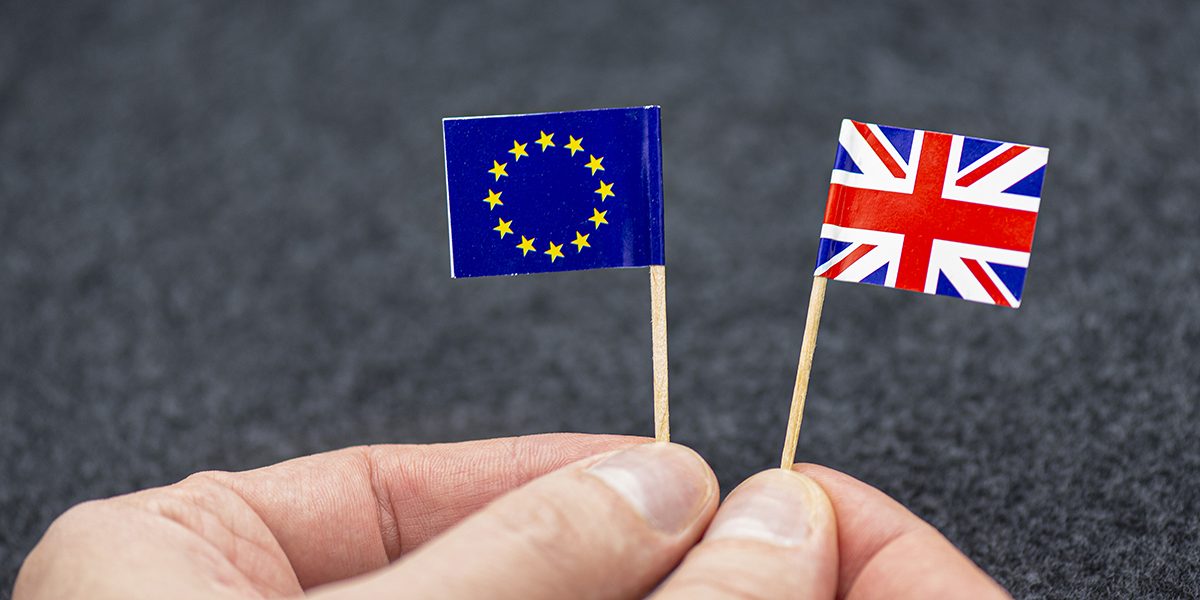 man-holding-small-paper-flags-of-eu-and-great-britain-as-symbol-of-brexit-concept-picture