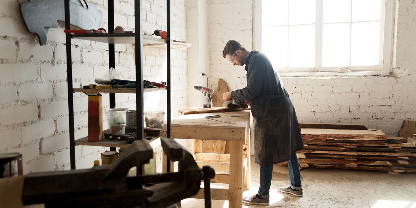 Skilled self-employed carpenter working with wood in carpentry w