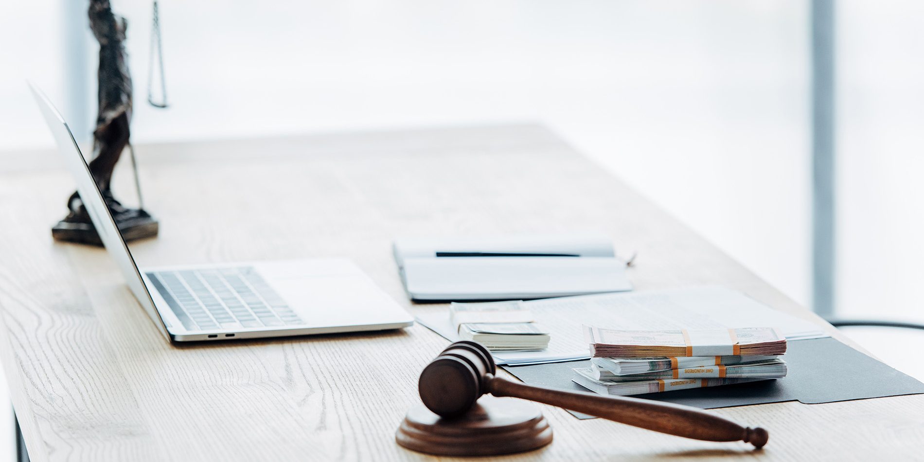 selective focus of money on folder near statuette of justice