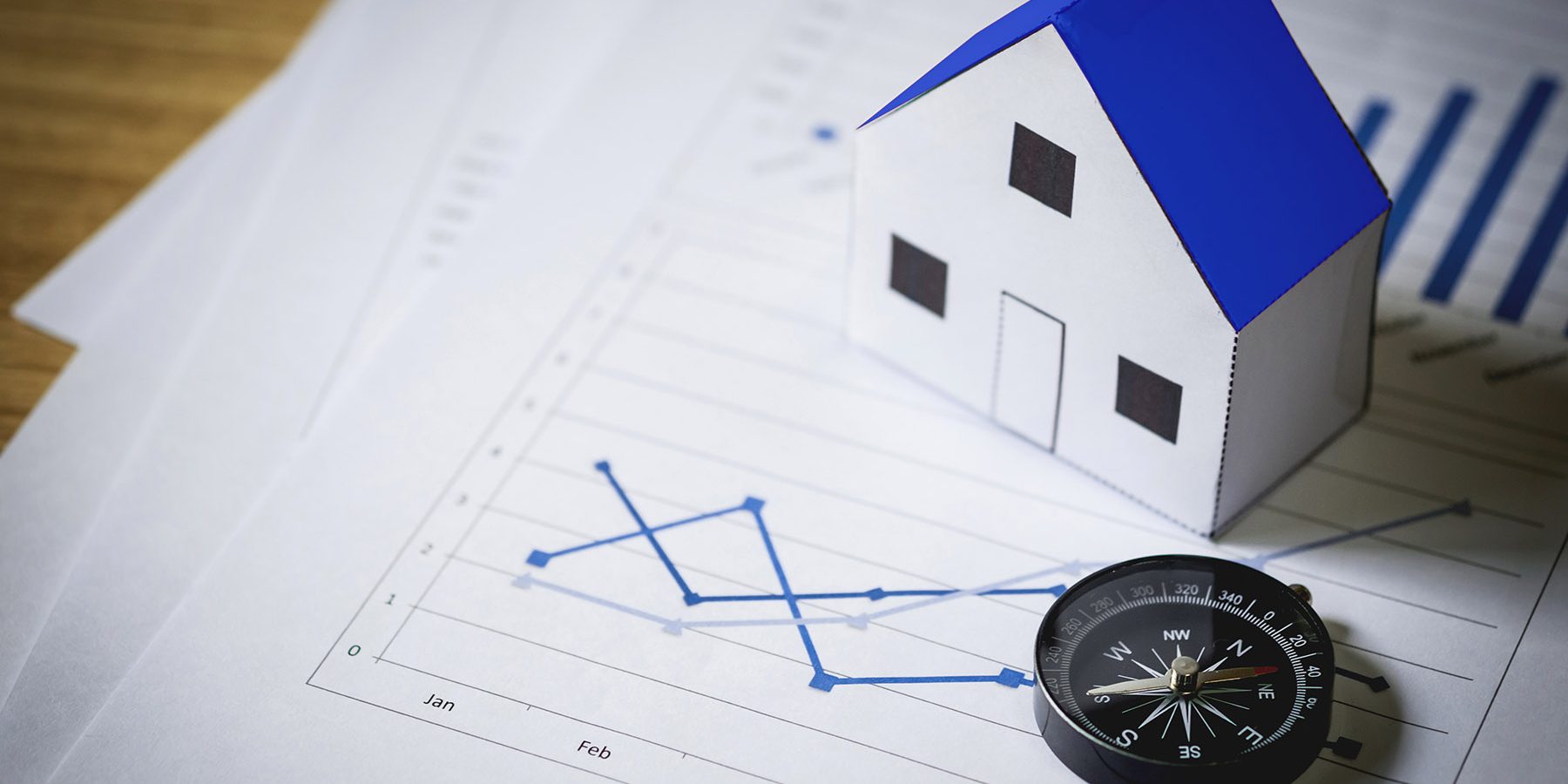 House model and compass on plan background, Real estate concept